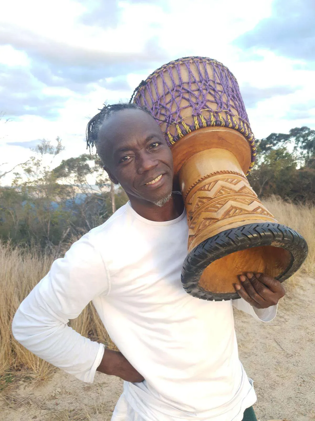 Epizo Bangoura carrying his djembe in Australian bushland